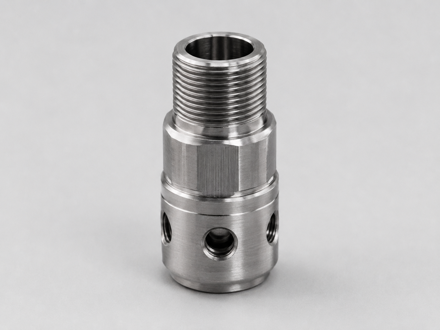 Threaded CNC machined component with controlled thread and burr areas